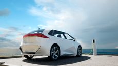 image of an electric vehicle next to a charger