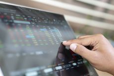 closeup of person using finger to look at small numbers on stock screen