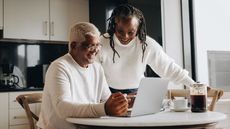 A senior couple planning for retirement while using a computer.